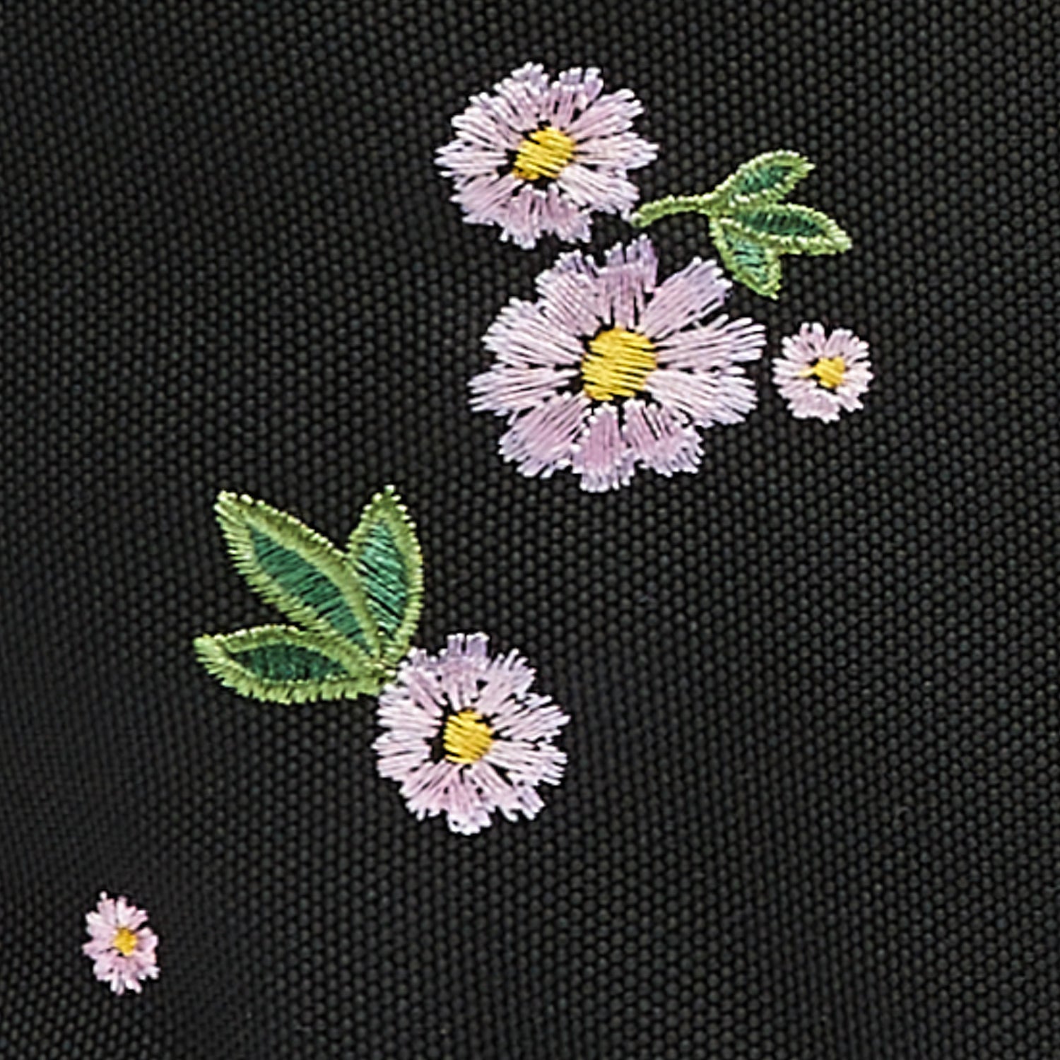 Ela Mo™ Rolltop Rucksack | Embroidery Edition Upsy Daisy. Nahansicht des Rucksacks mit floralem Muster.