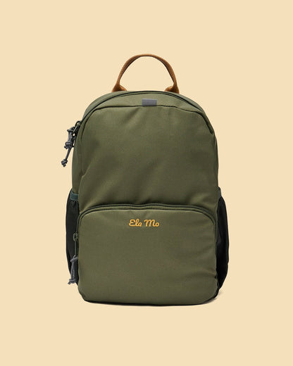 Ela Mo™ Kinderrucksack (3-6 Jahre) | Forrest Green. Ein grüner Rucksack auf gelbem Hintergrund.