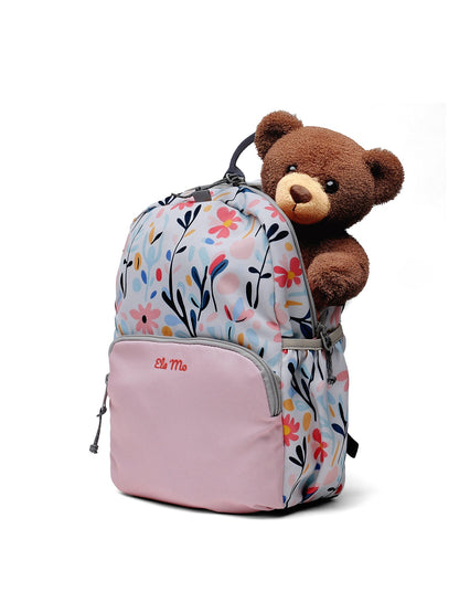 Ela Mo™ Kinderrucksack (3-6 Jahre) | Pastel Land. Aus dem geblümten rosa Rucksack schaut ein Teddybär heraus.