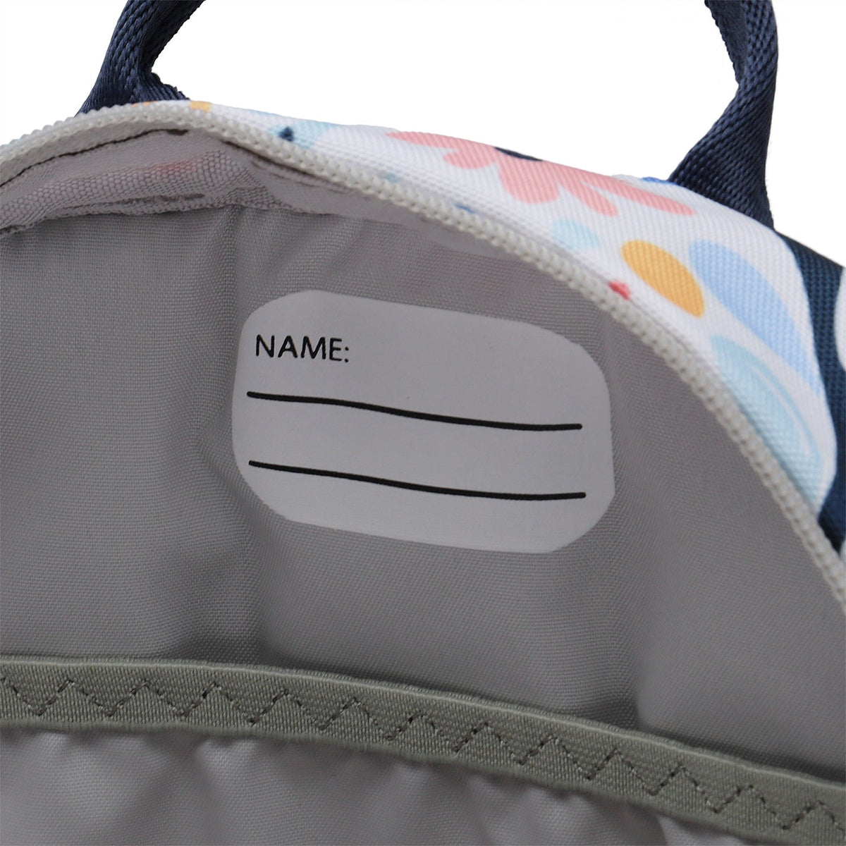 Ela Mo™ Kinderrucksack (3-6 Jahre) | Pastel Land. Im hellgrauen Innenbereich des Rucksacks befindet sich ein Namensschild.