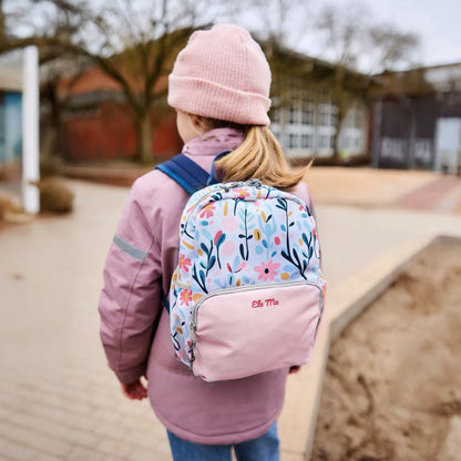 Ela Mo™ Kinderrucksack (3-6 Jahre) | Pastel Land. Ein kleines Mädchen trägt den rosafarbenen Rucksack, Ansicht von hinten.