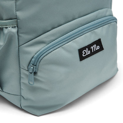 Ela Mo™ Mini Rucksack | Old Mint. Außenfach mit Herstellerlogo auf der Vorderseite des Rucksacks.