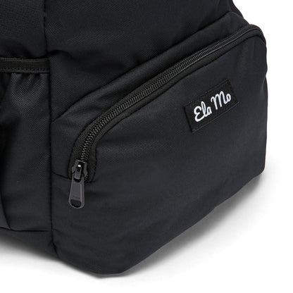Ela Mo™ Mini Rucksack | Schwarz. Außenfach mit Herstellerlogo auf der Vorderseite des Rucksacks.
