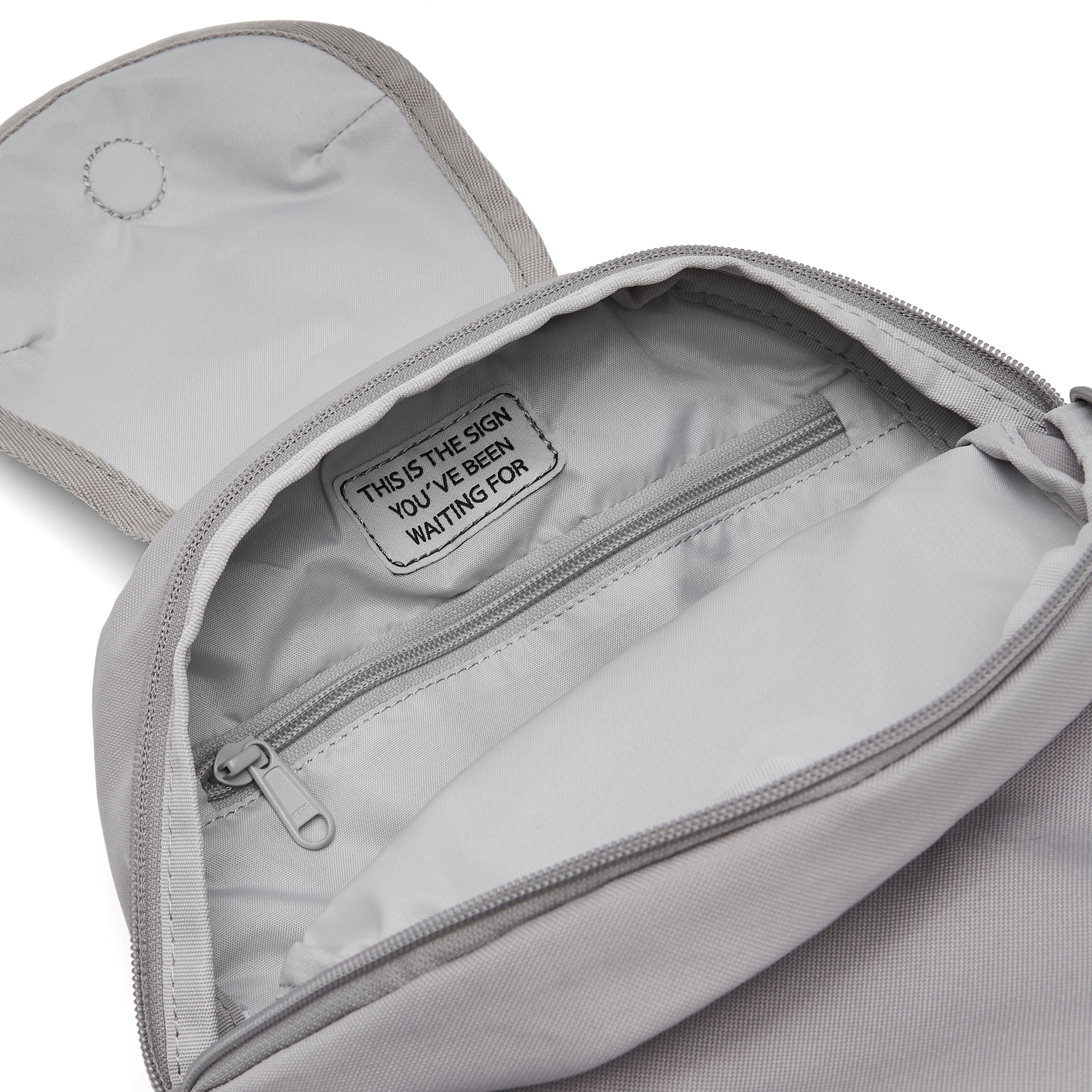 Ela Mo™ Mini Rucksack | Warm Grey. Hellgrauer Innenbereich des Rucksacks mit kleinem Fach und Reißverschluss.
