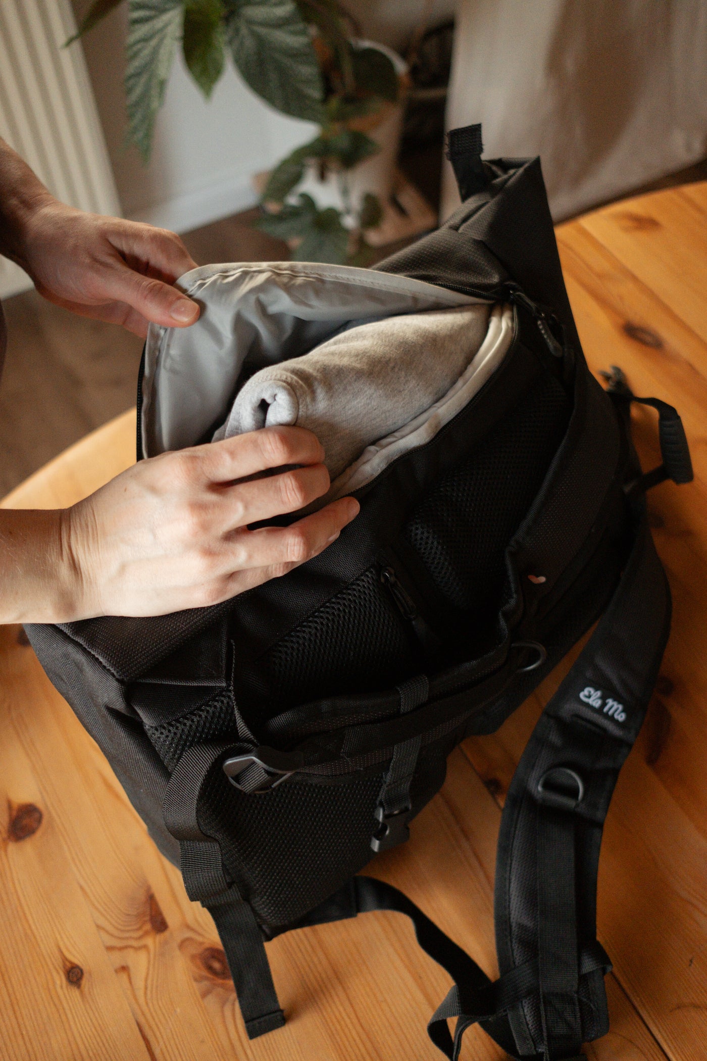 Ela Mo™ Rolltop Rucksack | Black Reflective. Seitenzugriff des Rucksacks mit Reißverschluss.