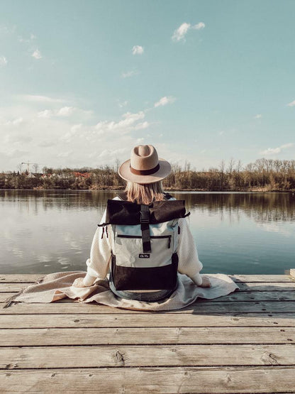 Ela Mo™ Rolltop Rucksack | The Grey. Eine Frau mit dem Rucksack auf dem Rücken – alltäglicher Lifestyle.